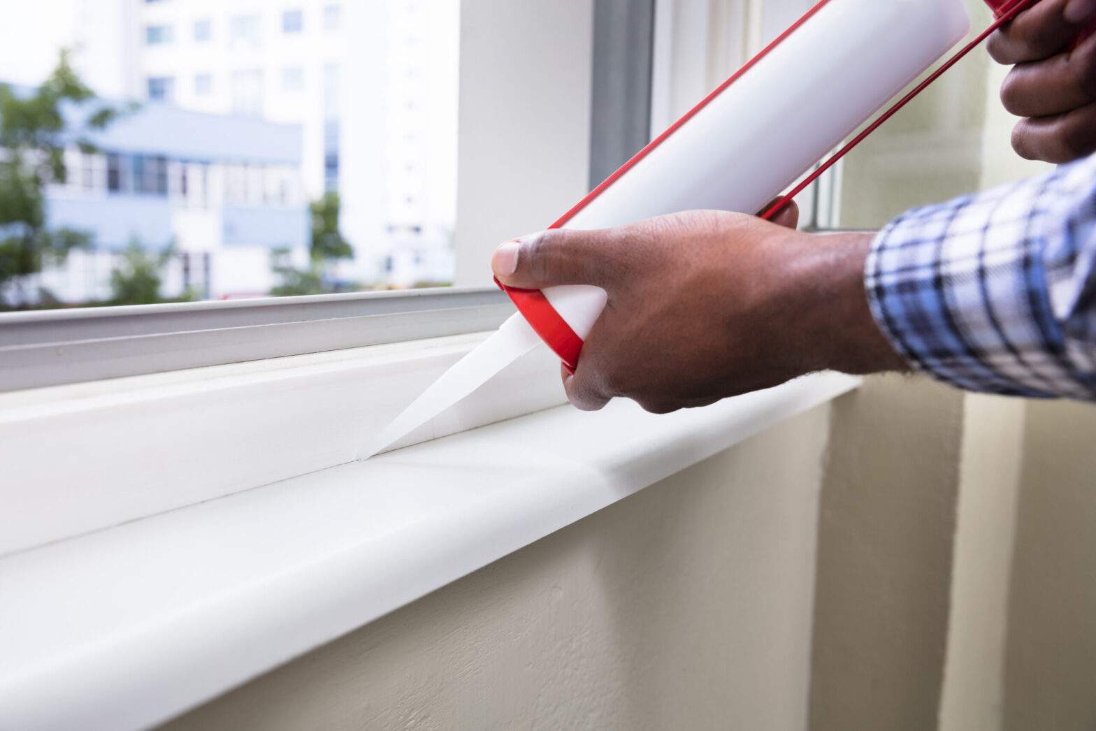 Men are applying caulk or sealant