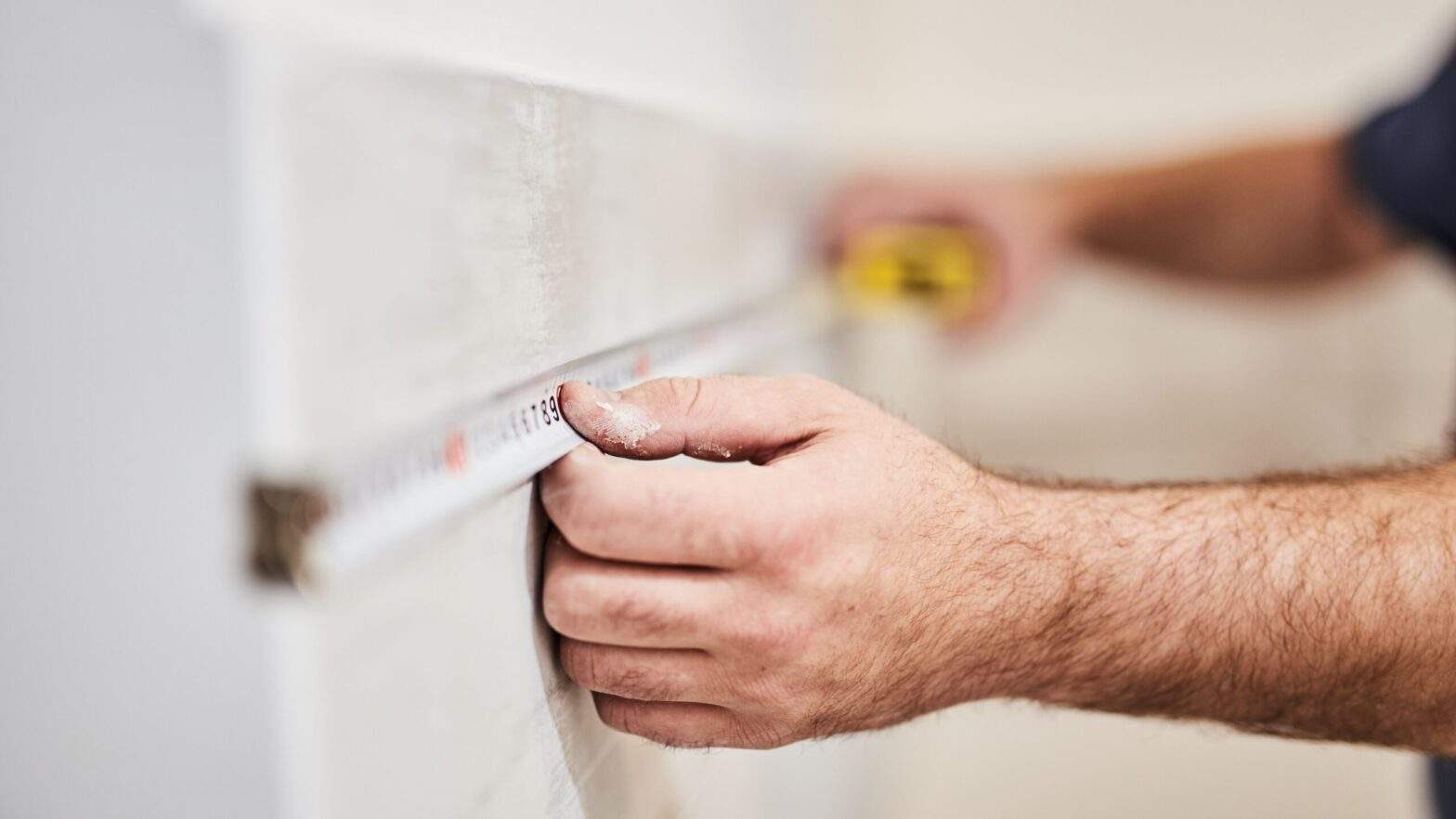 Men are measuring a wall.