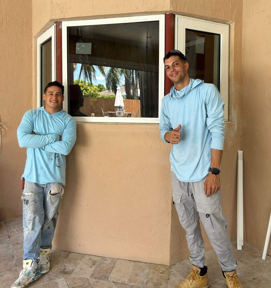 Two technicians are installing Impact Windows in Doral
